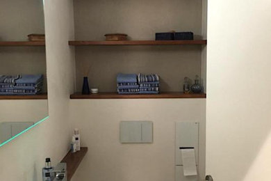 Kleine Moderne Gästetoilette mit Wandtoilette, beiger Wandfarbe, Fliesen in Holzoptik, Wandwaschbecken, braunem Boden und schwebendem Waschtisch in Frankfurt am Main