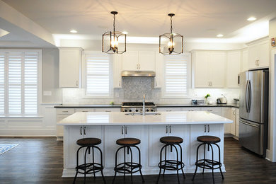 Inspiration for a mid-sized modern l-shaped dark wood floor and brown floor open concept kitchen remodel in Chicago with a double-bowl sink, white cabinets, gray backsplash, stainless steel appliances, an island, shaker cabinets and quartz countertops