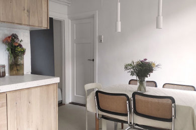Réalisation d'une salle à manger ouverte sur le salon minimaliste de taille moyenne avec un mur blanc, sol en béton ciré, aucune cheminée et un sol beige.