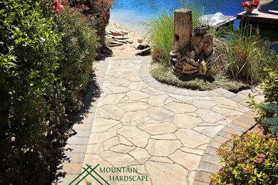 Traditional sloped garden in Boise with a garden path and concrete paving.