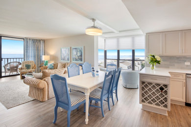 Exemple d'une salle à manger ouverte sur la cuisine bord de mer avec un mur gris et un sol en vinyl.