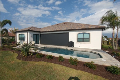 Inspiration for a large tropical backyard concrete paver patio remodel in Tampa with a roof extension