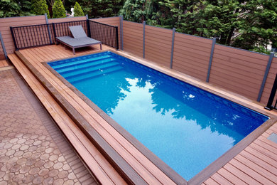 Mid-sized minimalist backyard privacy pool photo in New York