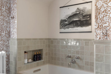 Example of a mid-sized transitional ceramic tile wallpaper drop-in bathtub design in Detroit with a niche