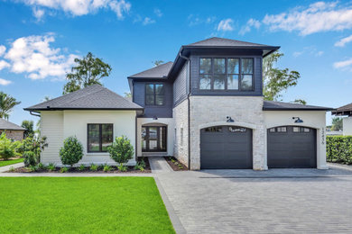 Mittelgroßes, Zweistöckiges Country Einfamilienhaus mit Steinfassade, schwarzer Fassadenfarbe, Schindeldach, schwarzem Dach und Verschalung in Orlando