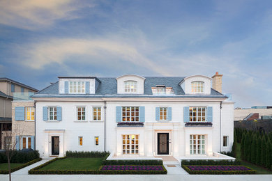 Expansive traditional three-storey white exterior in New York with stone veneer.