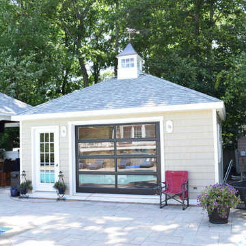 Pool house featuring a french door, glass design, hip roof, and a cupola.