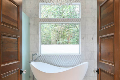 This is an example of a large midcentury master bathroom in New Orleans with shaker cabinets, medium wood cabinets, a freestanding tub, an open shower, white tile, marble, white walls, marble floors, an undermount sink, engineered quartz benchtops, white floor, an open shower, white benchtops, an enclosed toilet, a double vanity, a floating vanity and vaulted.