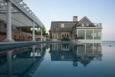 Pool fountain - large traditional side yard concrete paver and rectangular infinity pool fountain idea in Chicago