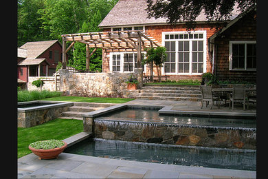 Example of a large cottage backyard stone and rectangular pool fountain design in New York