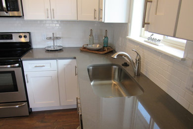 Open concept kitchen - mid-sized transitional u-shaped medium tone wood floor and brown floor open concept kitchen idea in Denver with an undermount sink, shaker cabinets, white cabinets, soapstone countertops, white backsplash, subway tile backsplash, stainless steel appliances and a peninsula