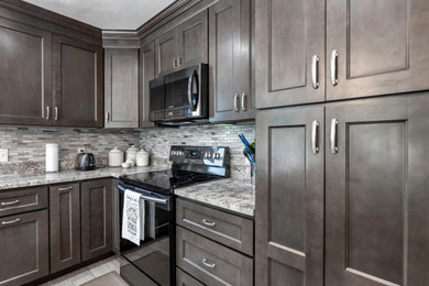 Example of a mid-sized mid-century modern l-shaped ceramic tile and gray floor kitchen pantry design in Minneapolis with shaker cabinets, dark wood cabinets, granite countertops, gray backsplash, an island and gray countertops
