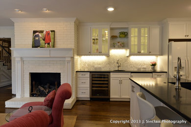 Inspiration for a large timeless u-shaped medium tone wood floor open concept kitchen remodel in Other with an undermount sink, recessed-panel cabinets, white cabinets, marble countertops, white backsplash, matchstick tile backsplash, stainless steel appliances and two islands