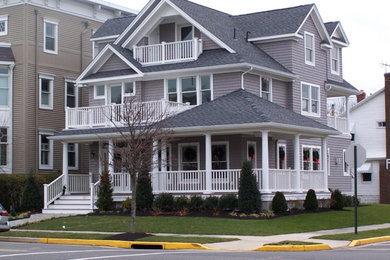 Large elegant gray three-story wood house exterior photo in Other with a hip roof and a shingle roof