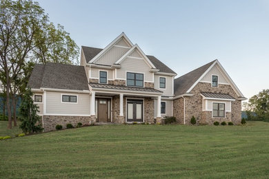 Example of a large arts and crafts beige two-story mixed siding exterior home design in Other with a shingle roof