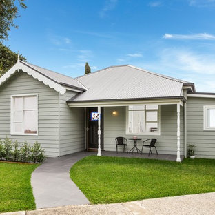 Bild på ett mellanstort shabby chic-inspirerat grått hus, med allt i ett plan, sadeltak och tak i metall