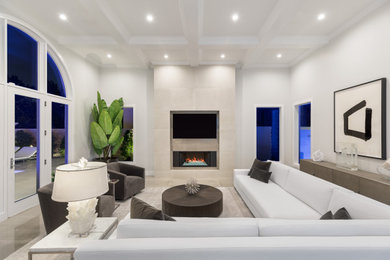 Large modern open concept living room in Las Vegas with grey walls, porcelain floors, a standard fireplace, a tile fireplace surround, a wall-mounted tv and grey floor.