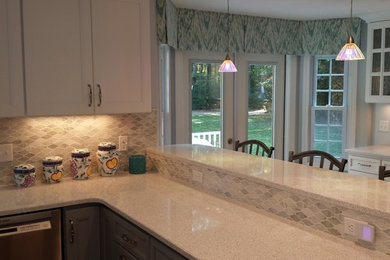 Mid-sized transitional u-shaped light wood floor kitchen photo in Boston with an undermount sink, quartz countertops, stainless steel appliances and a peninsula