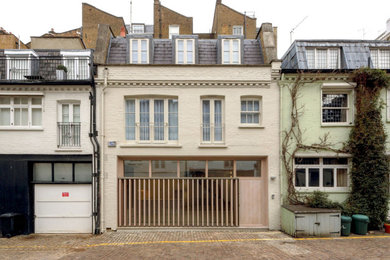 Inspiration for a medium sized and beige contemporary front house exterior in London with four floors, wood cladding, a mansard roof, a mixed material roof and a grey roof.