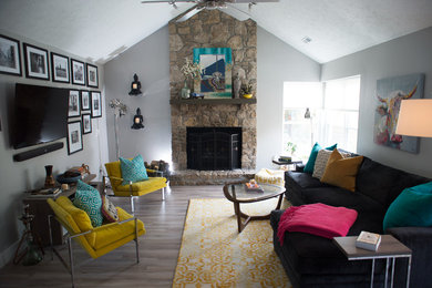 Inspiration for an eclectic open concept light wood floor living room remodel in Indianapolis with gray walls, a stone fireplace and a wall-mounted tv