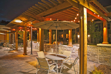 Inspiration for a large contemporary courtyard patio in Cleveland with brick pavers and a pergola.