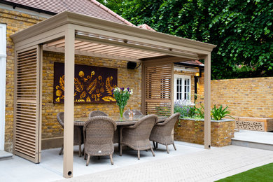 This is an example of a medium sized contemporary back garden in London.