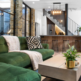 Exemple d'un sous-sol industriel semi-enterré et de taille moyenne avec un bar de salon, un mur blanc, un sol en bois peint, un sol beige, un plafond voûté et un mur en parement de brique.