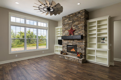 Inspiration for a mid-sized cottage open concept brown floor and laminate floor living room remodel in Grand Rapids with a standard fireplace, beige walls, a brick fireplace and a media wall