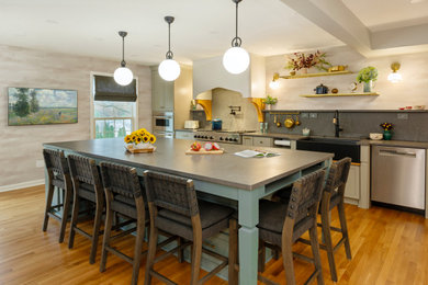 Kitchen pantry - large transitional single-wall medium tone wood floor kitchen pantry idea in Other with a farmhouse sink, beaded inset cabinets, green cabinets, quartz countertops, gray backsplash, quartz backsplash, stainless steel appliances, an island and gray countertops