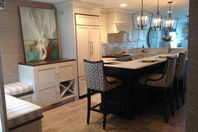 Inspiration for a mid-sized timeless l-shaped medium tone wood floor eat-in kitchen remodel in Grand Rapids with an undermount sink, shaker cabinets, white cabinets, marble countertops, white backsplash, ceramic backsplash, paneled appliances and an island