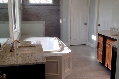 Example of a large classic master beige tile and ceramic tile ceramic tile bathroom design in Cincinnati with recessed-panel cabinets, medium tone wood cabinets, a one-piece toilet, green walls, an undermount sink and granite countertops