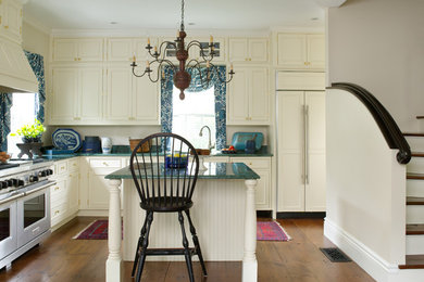 Kitchen - traditional l-shaped medium tone wood floor kitchen idea in Boston with beaded inset cabinets, beige cabinets, stainless steel appliances, an island, granite countertops and turquoise countertops