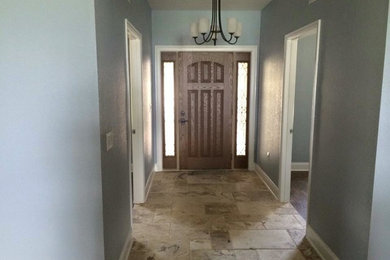 This is an example of a mid-sized modern foyer in Orlando with blue walls, ceramic floors, a single front door and a dark wood front door.