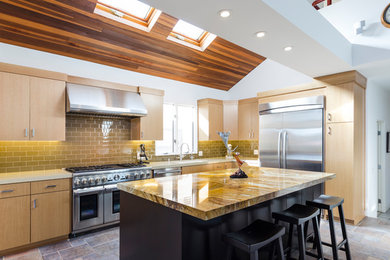 This is an example of a mid-sized contemporary l-shaped eat-in kitchen in Los Angeles with a double-bowl sink, flat-panel cabinets, light wood cabinets, quartzite benchtops, beige splashback, glass tile splashback, stainless steel appliances, ceramic floors, with island and multi-coloured floor.