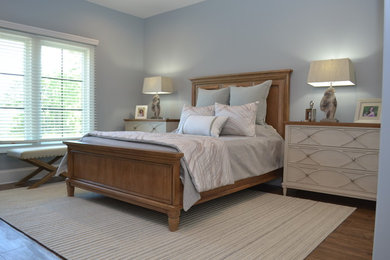 Bedroom - mid-sized transitional guest brown floor and medium tone wood floor bedroom idea in Other with blue walls and no fireplace