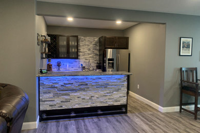 Small galley gray floor wet bar photo in Other with a drop-in sink, shaker cabinets, dark wood cabinets, laminate countertops, white backsplash and marble backsplash