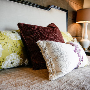 Ispirazione per una grande camera matrimoniale etnica con pareti beige, pavimento in legno massello medio, camino ad angolo e cornice del camino piastrellata