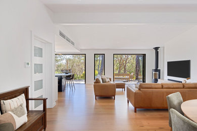 Design ideas for a contemporary open concept living room in Adelaide with plywood floors, a corner fireplace and a wall-mounted tv.
