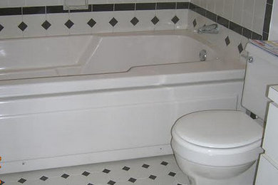Inspiration for a mid-sized timeless 3/4 white tile and ceramic tile ceramic tile and white floor bathroom remodel in Boston with an undermount sink, flat-panel cabinets, white cabinets, laminate countertops, a one-piece toilet and white walls
