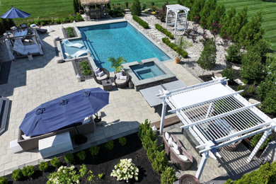 Minimalist backyard stone and rectangular pool landscaping photo in New York