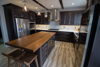 Inspiration for a mid-sized transitional u-shaped vinyl floor eat-in kitchen remodel in Other with shaker cabinets, dark wood cabinets, wood countertops, white backsplash, mosaic tile backsplash, stainless steel appliances and an island