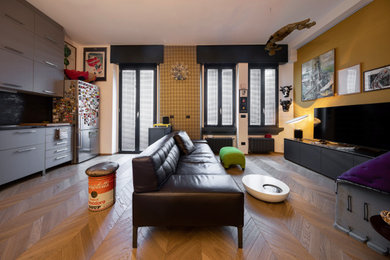 Ejemplo de sala de estar ecléctica pequeña con paredes amarillas, suelo de madera clara y papel pintado