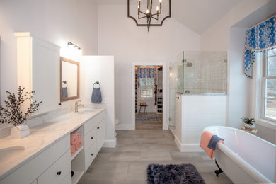 Inspiration for a large country master white tile and porcelain tile porcelain tile, gray floor and double-sink bathroom remodel in Boston with shaker cabinets, white cabinets, a one-piece toilet, white walls, an undermount sink, quartz countertops, a hinged shower door, white countertops, a niche and a built-in vanity