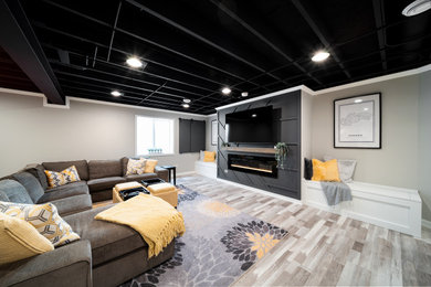 Cette image montre un sous-sol design avec un mur beige, un sol en vinyl, un sol beige et poutres apparentes.