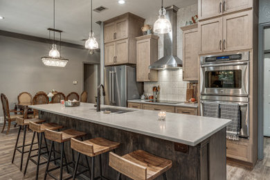 Mid-sized eclectic single-wall vinyl floor and brown floor eat-in kitchen photo in Dallas with an undermount sink, shaker cabinets, quartz countertops, gray backsplash, ceramic backsplash, stainless steel appliances, an island and gray countertops