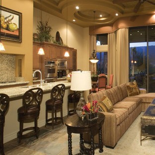 Ejemplo de salón mediterráneo, sin televisor, con paredes beige, suelo de pizarra, chimenea tradicional, marco de chimenea de hormigón y suelo multicolor