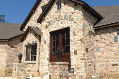 Inspiration for a mid-sized rustic red two-story brick exterior home remodel in Other