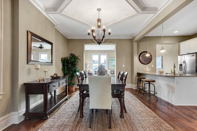 This is an example of a transitional open plan dining in St Louis with beige walls and dark hardwood floors.
