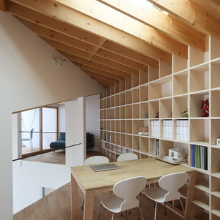 This is an example of a modern home office and library in Kyoto with white walls, medium hardwood flooring and brown floors.