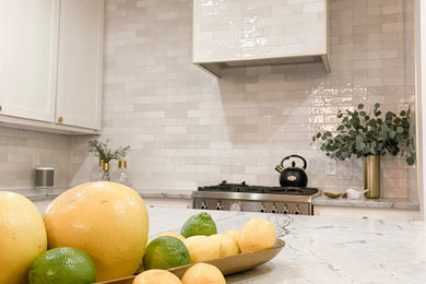 Mid-sized elegant porcelain tile kitchen photo in Austin with a farmhouse sink, shaker cabinets, white cabinets, quartzite countertops, white backsplash and gray countertops